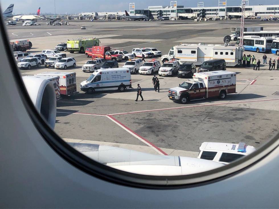 Personal de emergencias este miércoles alrededor del avión de Emirates que está en cuarentena en el aeropuerto JFK de Nueva York. Fotografía tomada por un pasajero desde dentro de la aeronave.