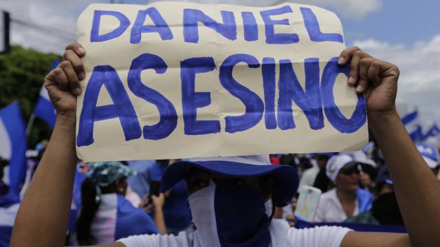 Una manifestante sostiene un cartel contra Ortega.