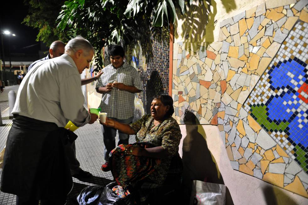 Voluntarios de San Egidio reparten alimentos y bebida entre personas en situación de calle en Flores.
