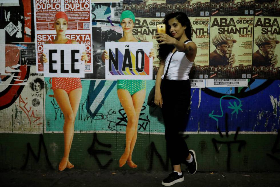 Una mujer se toma un selfie junto a un cartel de rechazo a Bolsonaro, el 29 de septiembre en SÃ£o Paulo.
