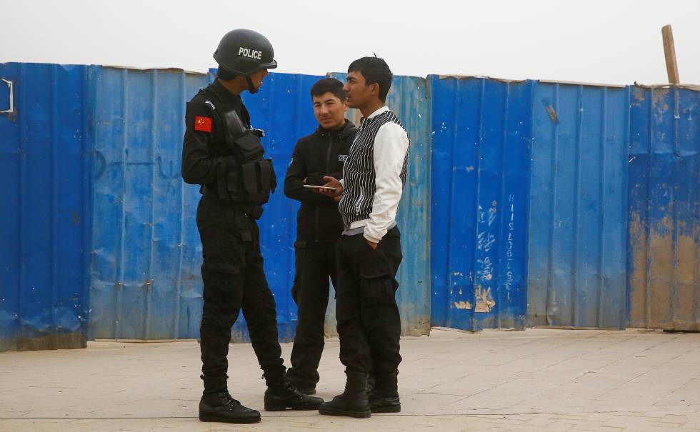 Un policÃ­a chino habla con dos ciudadanos en Kashgar (Xinjiang), en marzo de 2017.