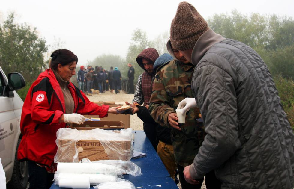Personal de la Cruz Roja entrega el desayuno en Velika Kladusa.