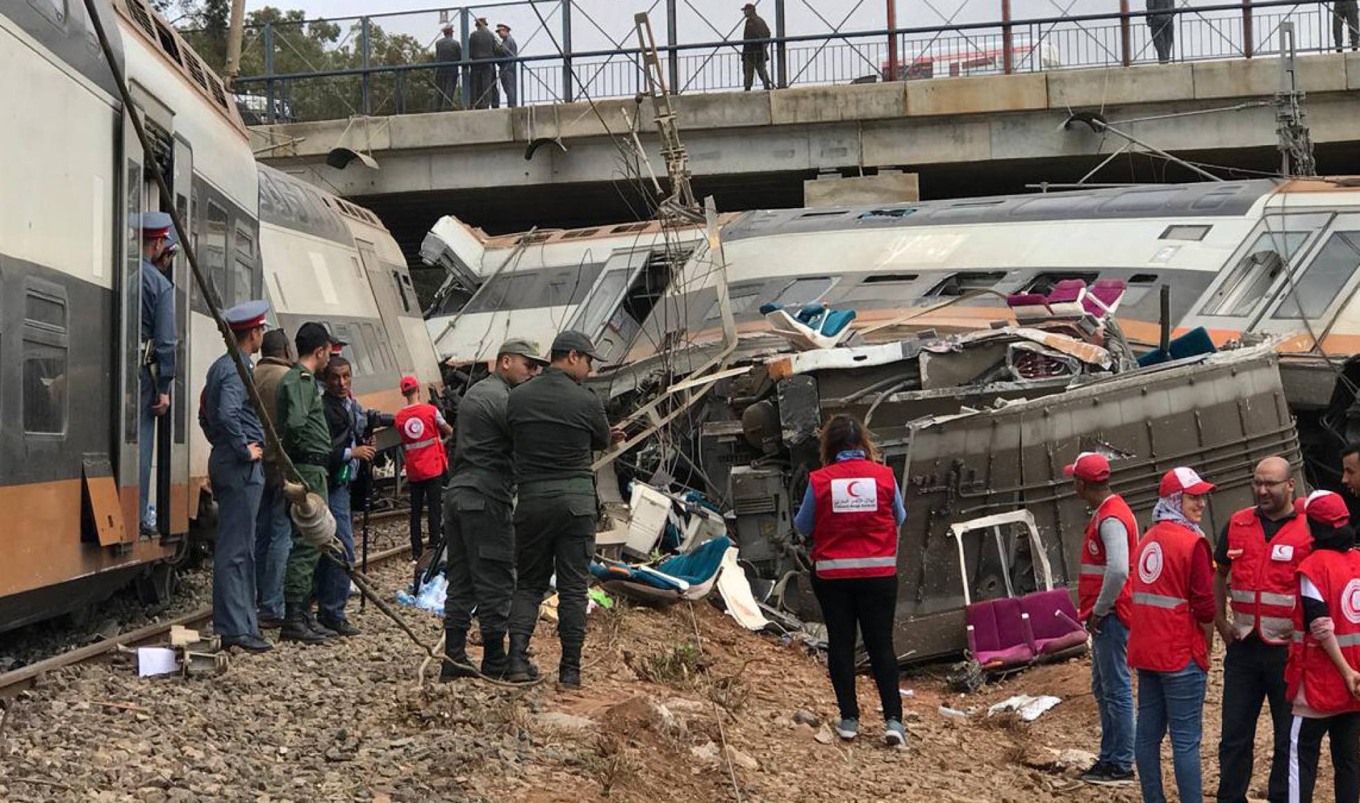 Varios trabajadores de emergencias llegan a la zona del accidente de tren en la localidad de Sidi Bouknadel, en Marruecos.