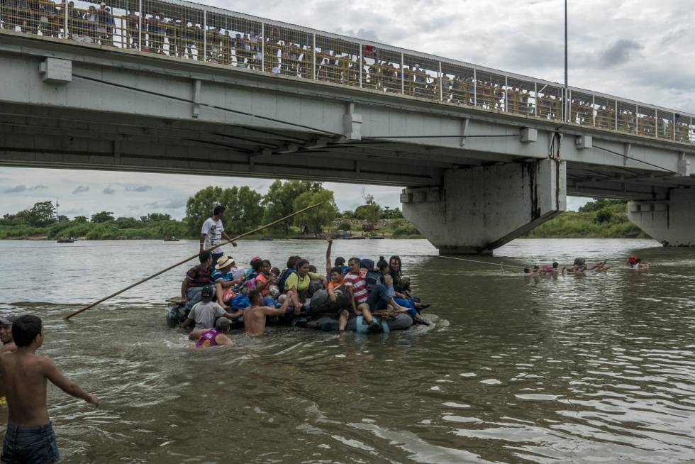 Un grupo de migrantes cruzan en balsa el río Suchiate para llegar a México.