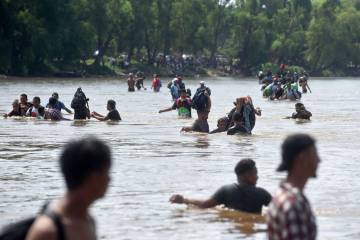 Migrantes centroamericanos atravesando el río Suchiate en la frontera entre México y Guatemala
