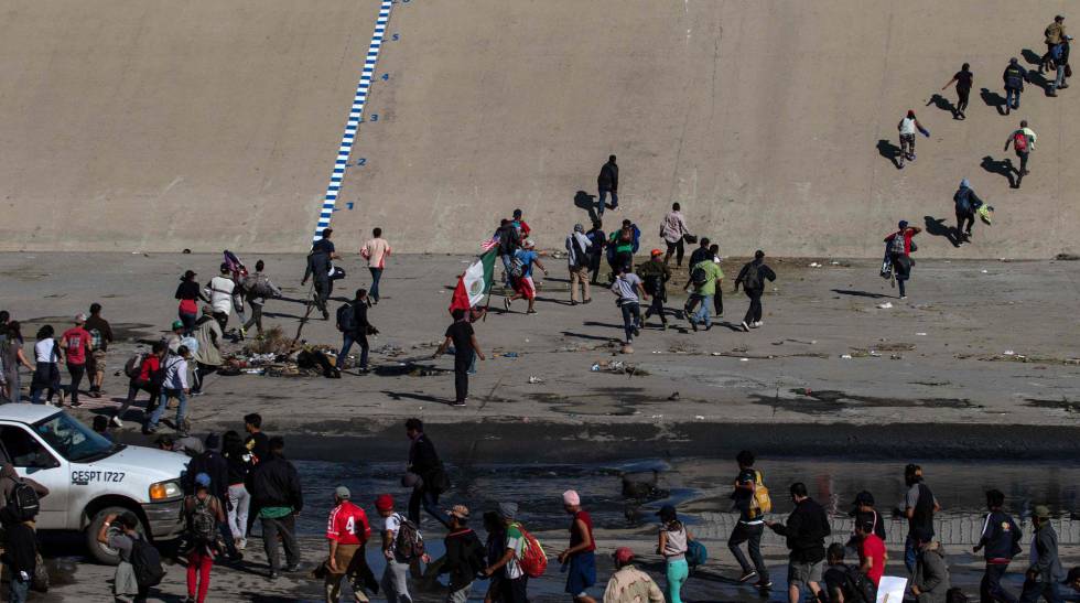 Un grupo de inmigrantes trata de llegar a la valla de EE UU, en Tijuana el 25 de noviembre.