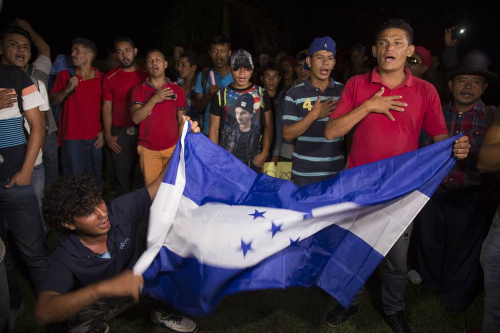 Miembros de la caravana ondean una bandera hondureña.