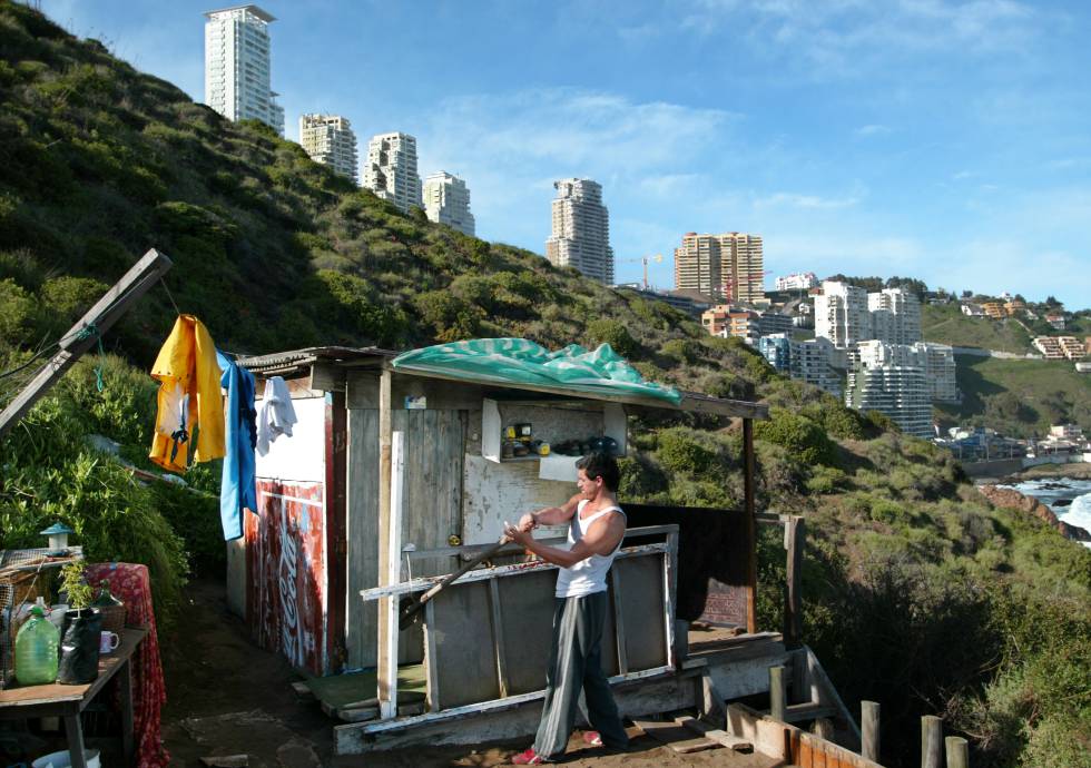 El chileno Marco Henrique, de 40 aÃ±os, parchea la choza donde vive desde hace 15 aÃ±os, en una colina de ViÃ±a del Mar.