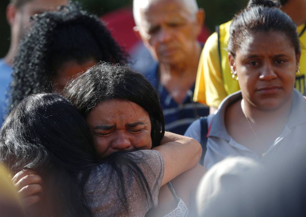 Dos familiares, en el entierro de vÃctimas de la avalancha de lodo.