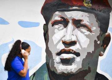 Una mujer camina junto a una pared con una pintura de Hugo Chávez, el 16 de enero en Caracas.