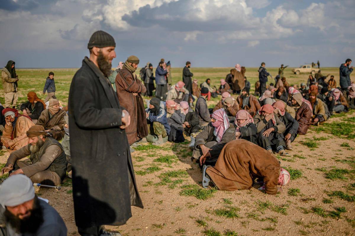 Supuestos miembros del autodenominado Estado Islámico esperan a ser registrados por fuerzas kurdas tras salir de Baguz, el último reducto del califato al este de Siria.