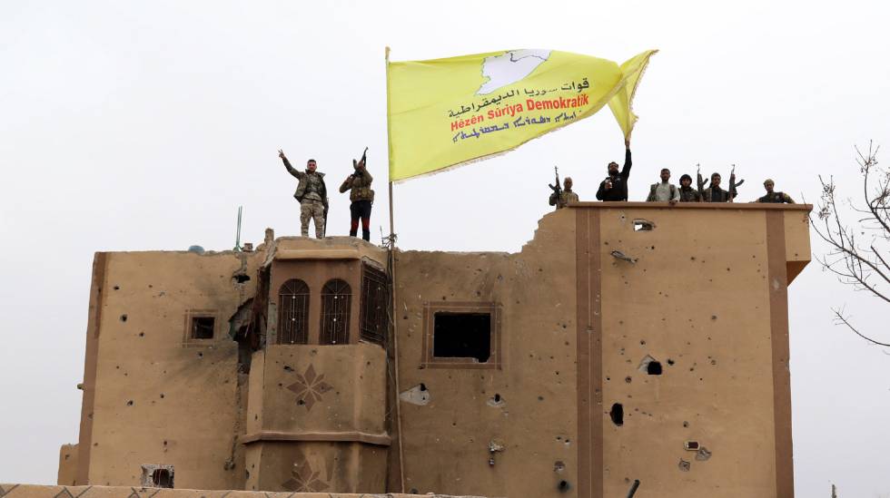 Combatientes de las Fuerzas DemocrÃ¡ticas Sirias (FDS) ondean una bandera en Baguz,Siria. 