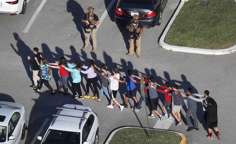 Alumnos del instituto de Parkland son escoltados por un soldado, febrero de 2018.