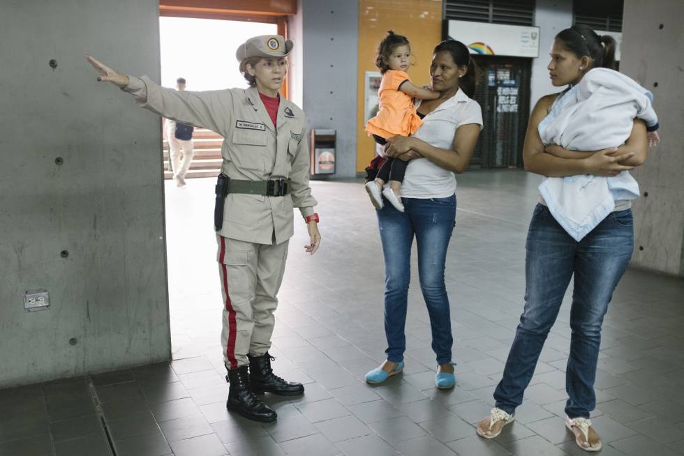 Carolina González ayuda a usuarios del metro de Caracas.