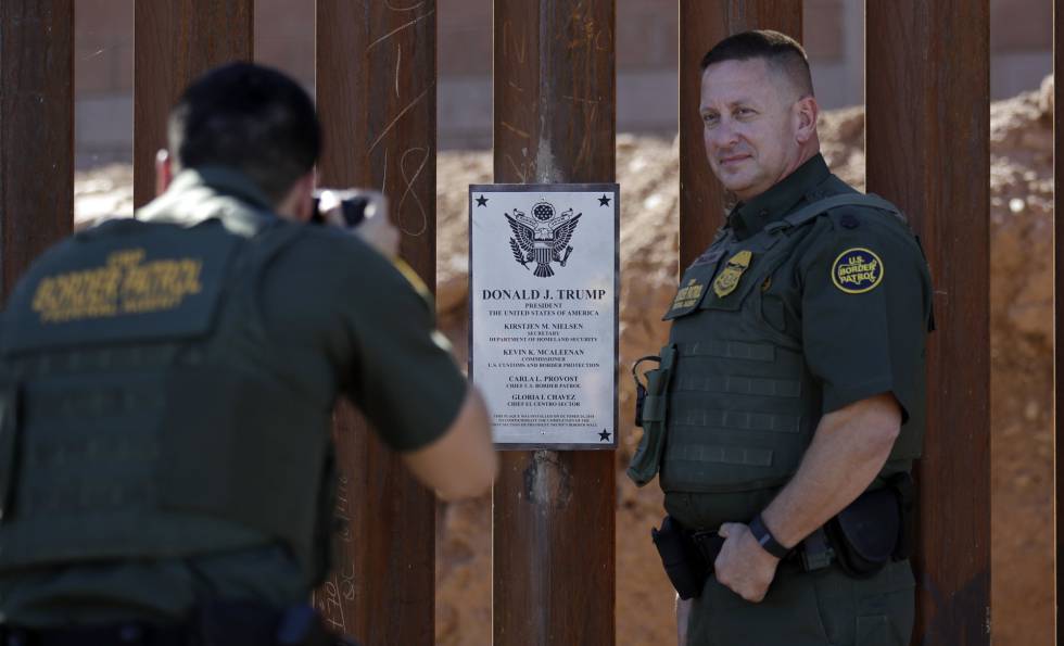 Dos agentes de la policÃa fronteriza se hacen fotos el pasado octubre en el trozo de valla que Trump visitó este viernes.