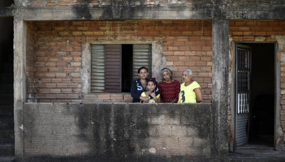 La familia Anunciação, ante su casa, en Congonhas. Solo una colina las separa de una balsa.