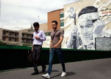 Un par de iraníes camina cerca de un mural con la imagen de un mártir en una calle de Teherán. Este miércoles el régimen ha anunciado que abandona parte del acuerdo nuclear de 2015.