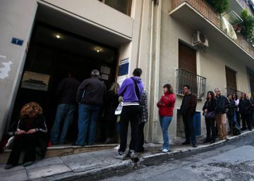 Desemplados hacen cola en una oficina del Servicio Nacional de Empleo para recoger cheques de ayuda, en Atenas.