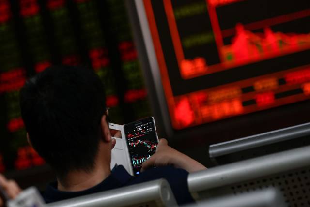 Un inversor mira los movimientos del mercado, este martes en Pekín.