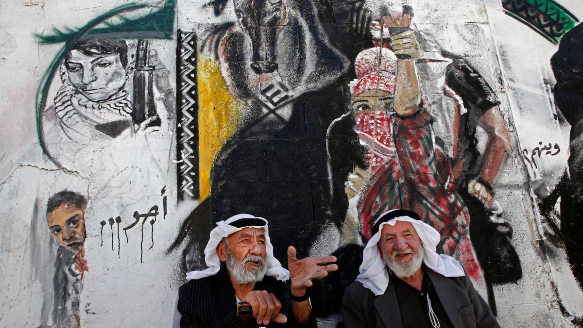 Dos palestinos ante un mural en El Arub, el martes en Cisjordania.