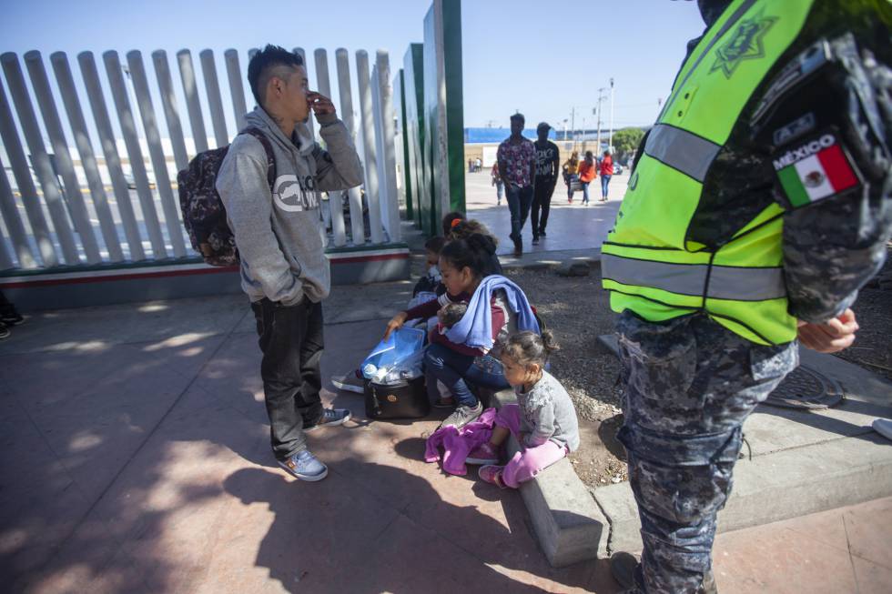 Migrantes en el cruce fronterizo El Chaparral, en Tijuana, este domingo.