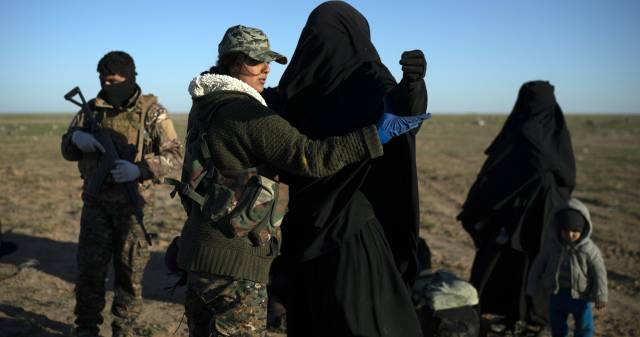 Una miliciana kurda registra a una mujer evacuada de la zona controlada por el ISIS, en Baguz, el pasado 1 de marzo.
