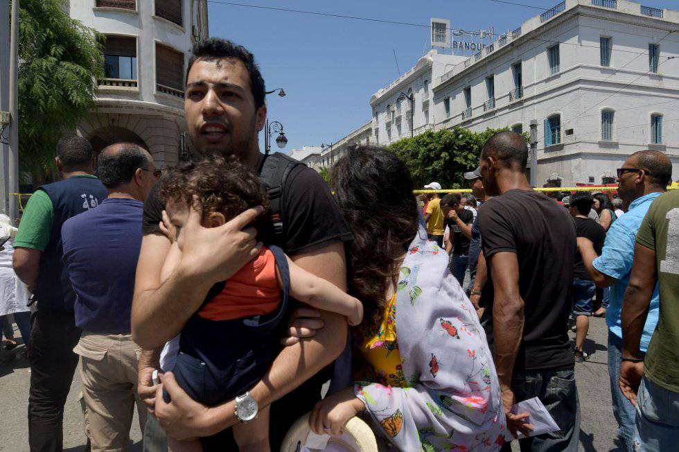 Un hombre protege a un niño en el centro de Túnez tras el atentado en la calle Charles de Gaulle este jueves.