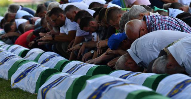 Musulmanes bosnios rezan los cuerpos de 33 hombres recientemente identificados como víctimas de Srebrenica, el 11 de julio de 2019. 