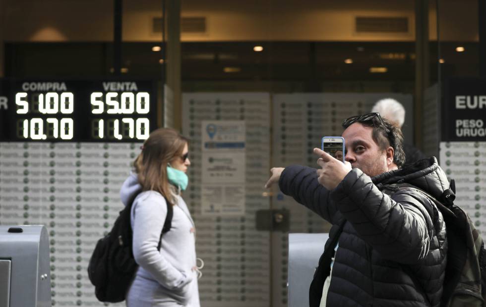 Un hombre se hace un selfi frente a una casa de cambio, este lunes en Buenos Aires.