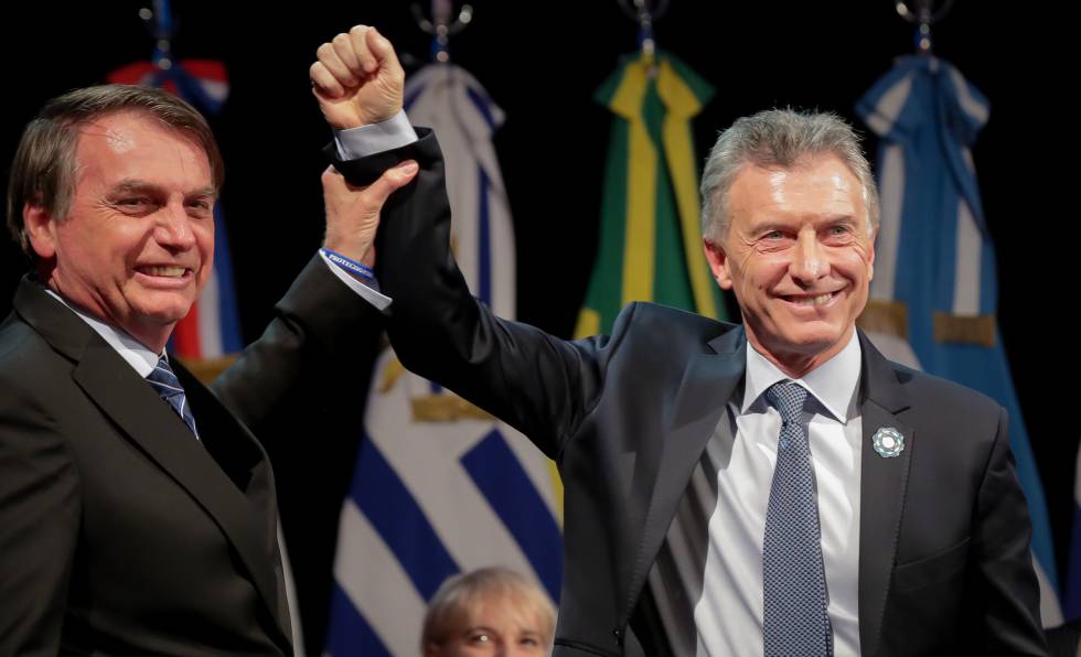 El brasileño Jair Bolsonaro levante el puño de su par argentino, Mauricio Macri, durante la cumbre de presidente del Mercosur realizada en Santa Fe, Argentina, el pasado 17 de julio.