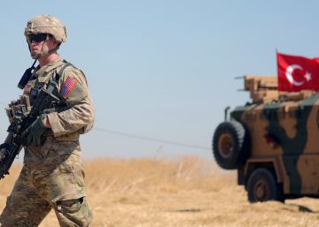 Un soldado estadounidense camina junto a un vehiculo militar turco durante una patrulla conjunta cerca de la norteña localidad siria de Tel Abiad, el pasado mes de septiembre.