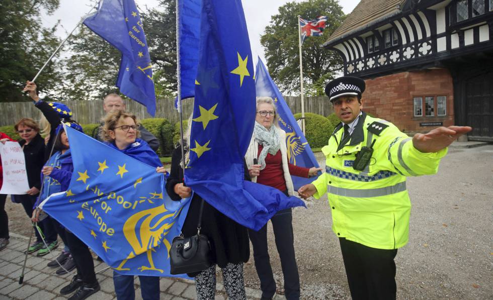 Un policía desvía a los manifestantes concentrados este jueves ante la residencia de Wirral (Reino Unido) donde se han reunido Johnson y Varadkar.