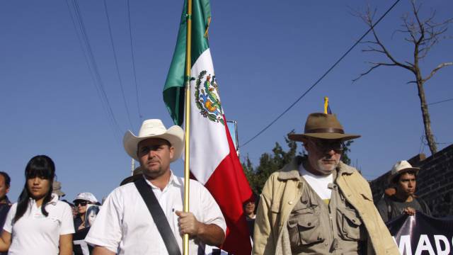 Julián LeBarón con la bandera de México.