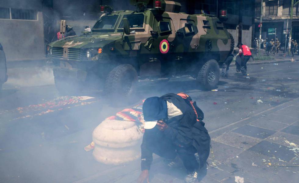 Un hombre junto a un ataúd se protege del gas lacrimógeno en La Paz, este miércoles.