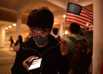 Un manifestante prodemocracia sostiene una bandera de Estados Unidos mientras revisa su teléfono, este jueves en Hong Kong.