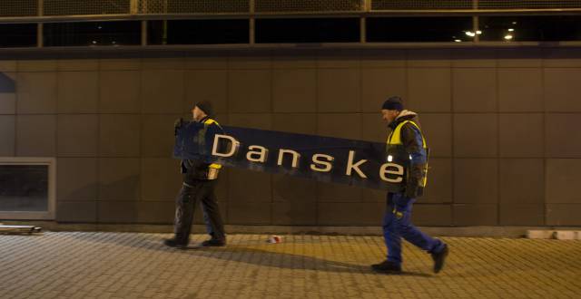 Dos operarios se llevan el cartel de Danske Bank en la filial de Tallin (Estonia), el 5 de octubre de 2019.