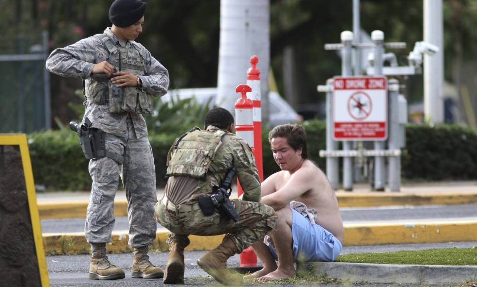 Agentes militares atienden a un hombre fuera de la base de Pearl Harbor.