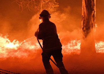 Un bombero trata de apagar el fuego en Nowra, Nueva Gales del Sur, Australia, este martes.