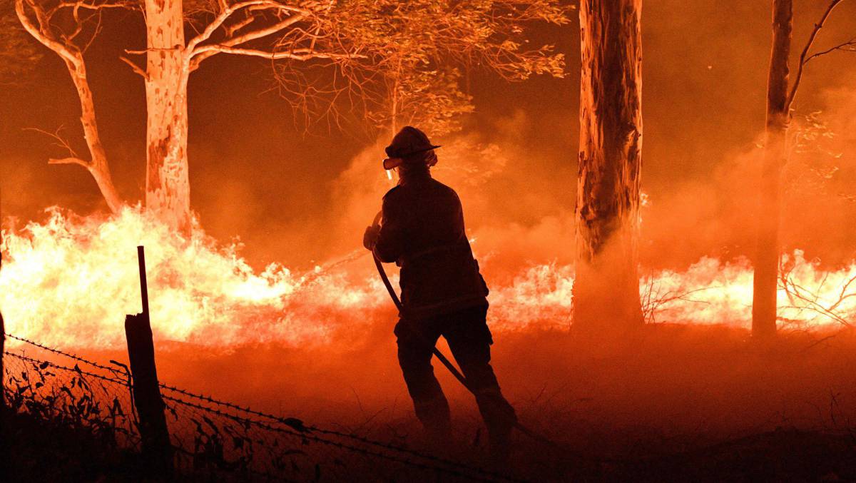 Un bombero trata de apagar el fuego en Nowra, Nueva Gales del Sur, Australia, este martes.
