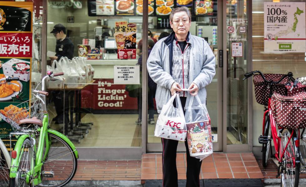 Un hombre sale de un KFC en Tokio (Japón) con su menú navideño.