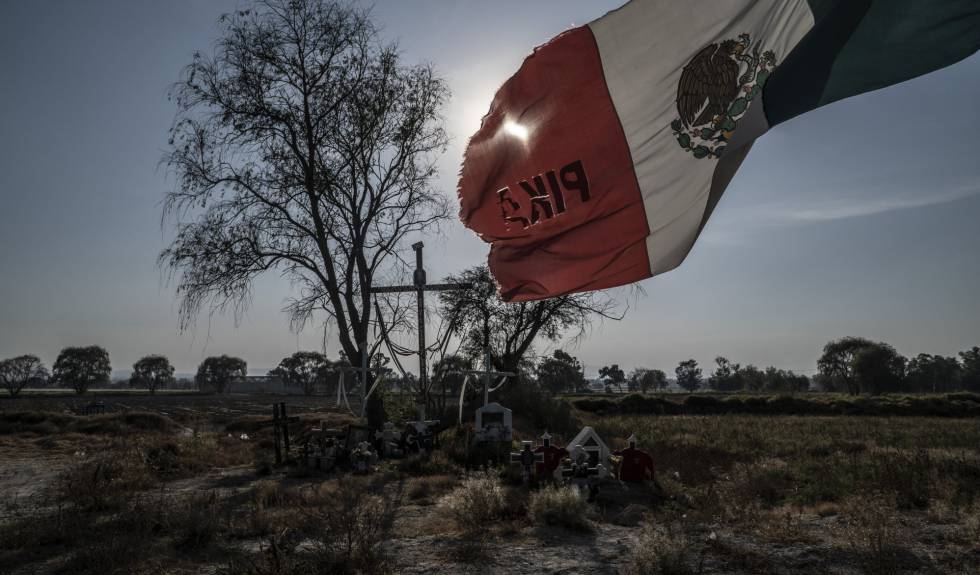 Una bandera de México ondea frente a un altar improvisado en el lugar del accidente.