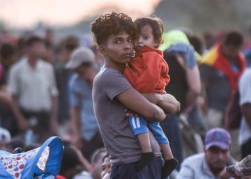 Un migrante centroamericano carga a su bebé en la última caravana de enero.