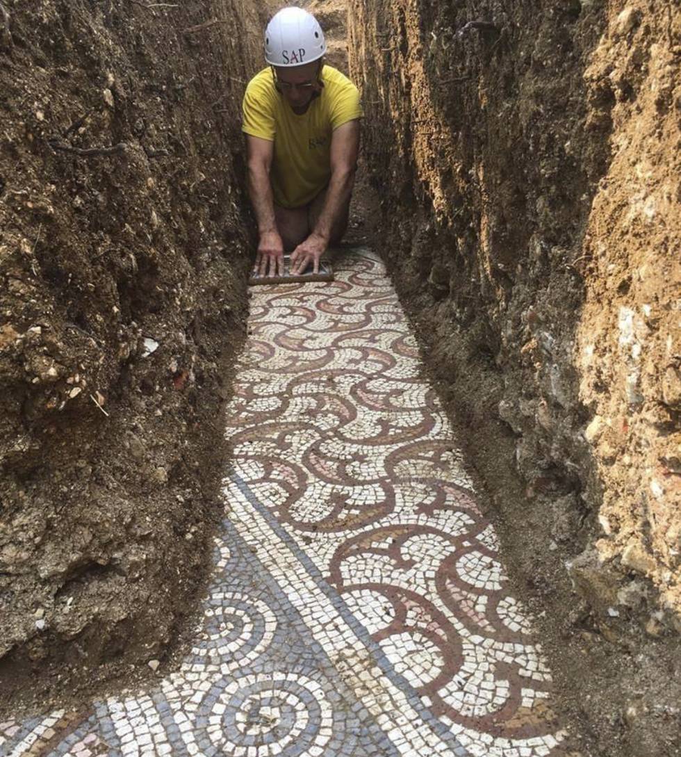 Un hombre realiza tareas de limpieza del mosaico romano hallado en Roma. 