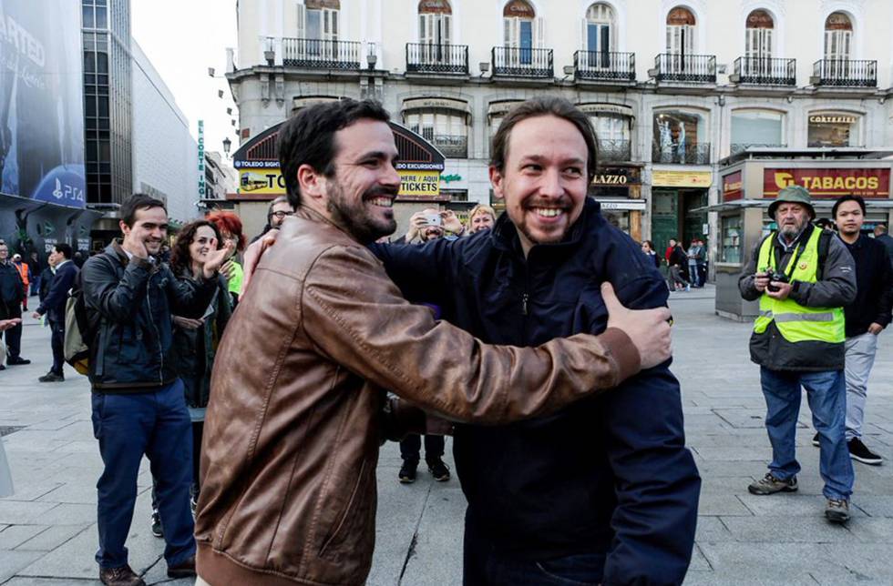 Alberto Garzón y Pablo Iglesias se abrazan en la Puerta del Sol tras anunciar su acuerdo electoral.