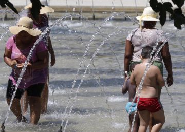 Numerosas personas se refrescan en una fuente de Madrid R&iacute;o.