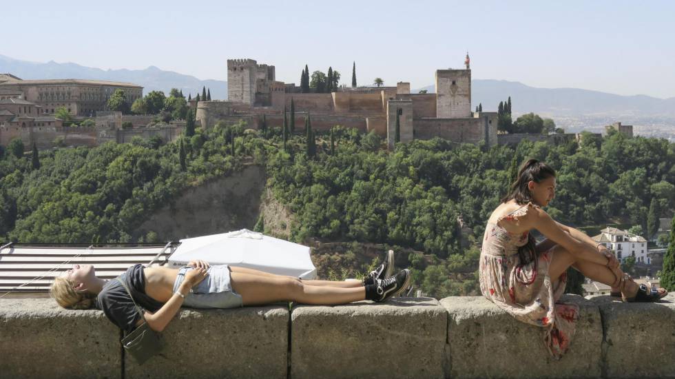 Unos turistas descansan y toman el sol en Granada, en alerta naranja por calor.
