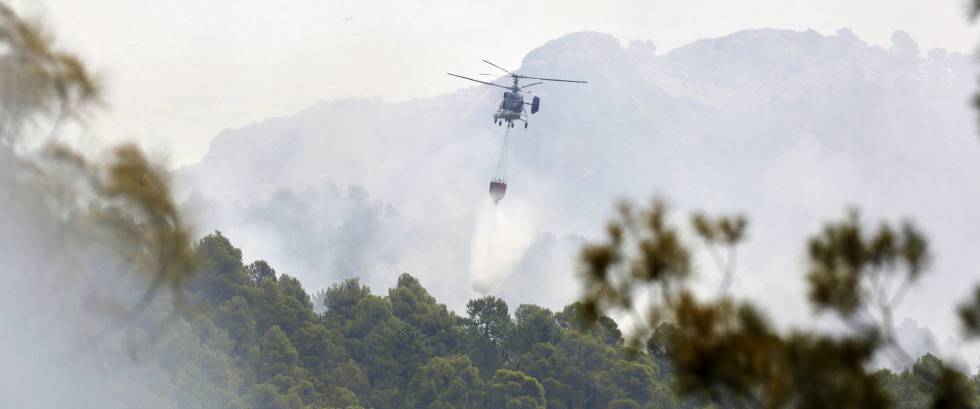 Un helicóptero lanza agua sobre el incendio de Yeste (Albacete).