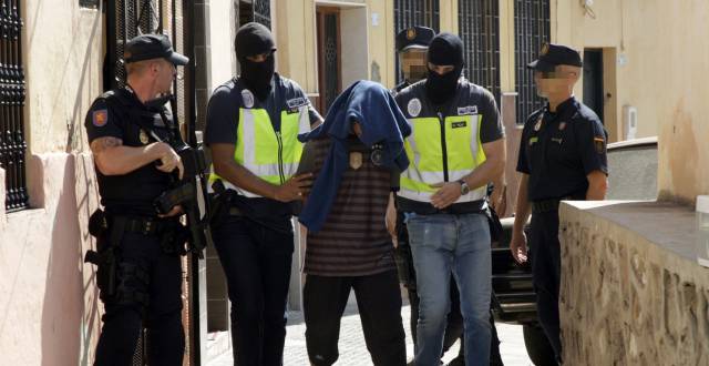 Efectivos de la Policía Nacional traslada a una persona detenida en Melilla.