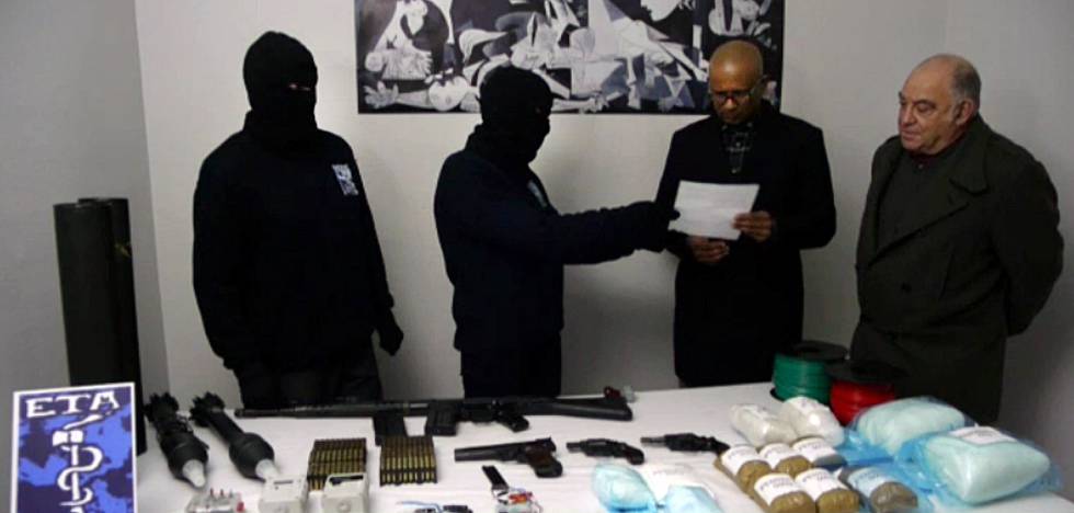 Dos encapuchados de ETA entregan el inventario de armas y explosivos a miembros del grupo de verificación en febrero de 2014.rn 