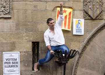 Hombre encaramado en la fachada del Ayuntamiento de Lleida levanta el pu&ntilde;o en apoyo del refer&eacute;ndum.